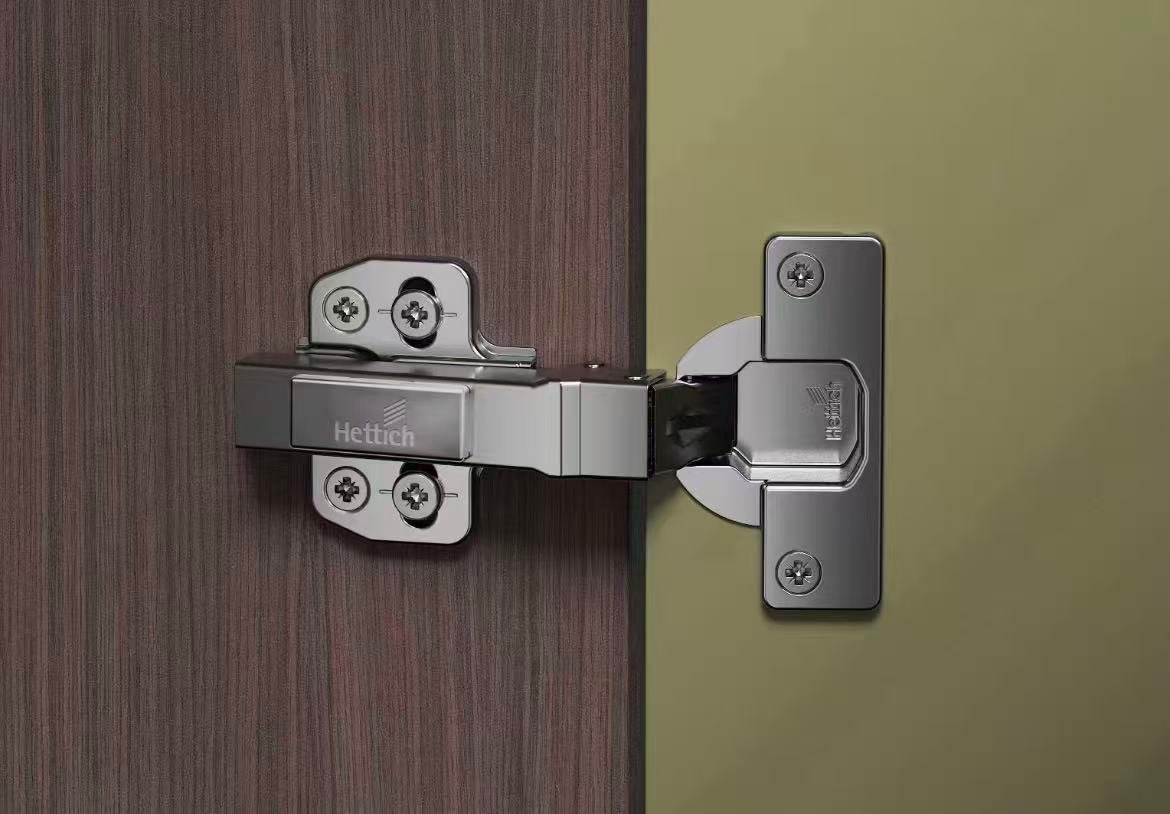Concealed hinge fitted between a wood-grain aluminum cabinet door and the cabinet side panel